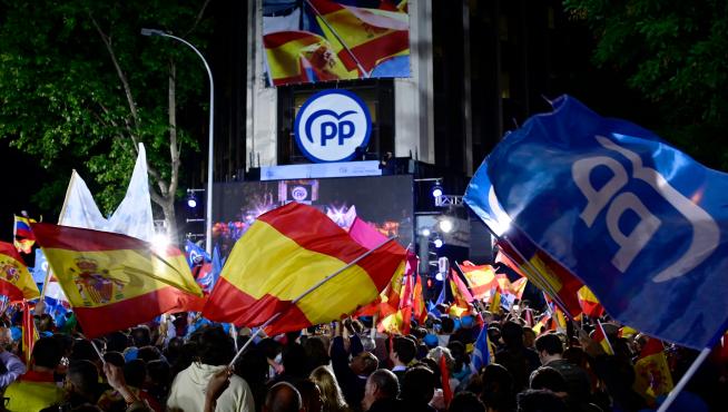 Cientos de militantes del PP celebran el resultado electoral delante de la sede nacional del partido, en la calle Génova de Madrid.