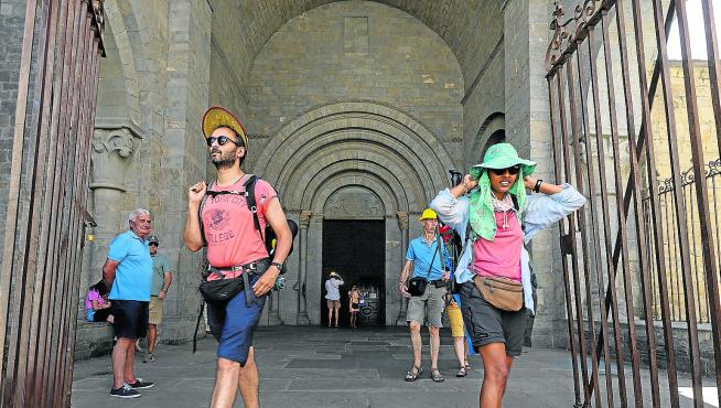 Turistas, ayer saliendo y entrando de la Catedral de Jaca, localidad muy concurrida durante el puente de agosto.