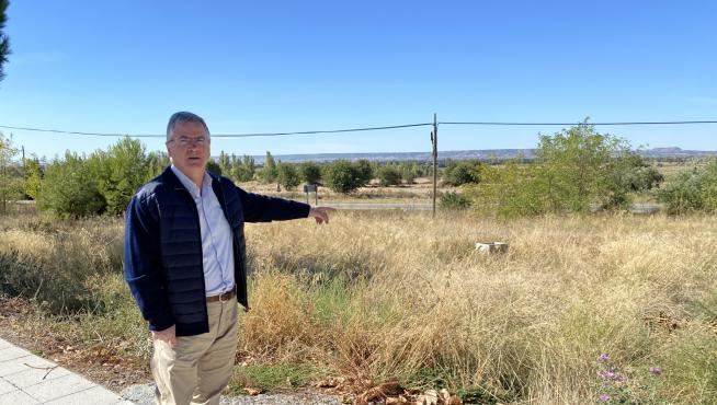 El alcalde de Castejón del Puente, Antonio Comps, junto al terreno donde se va a edificar.