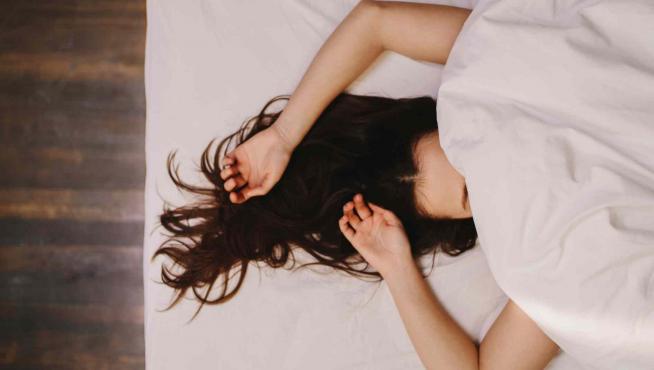 Una mujer durmiendo en la cama.