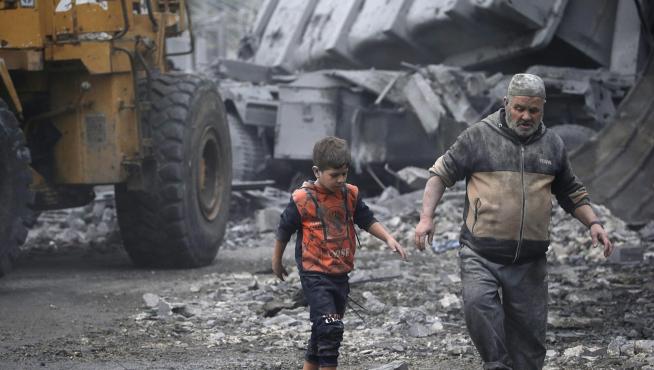 Los palestinos se abren paso entre los escombros tras los ataques aéreos israelíes contra Deir Al Balah, en el sur de la Franja de Gaza