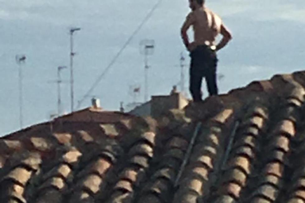 no de los jóvenes encaramado al tejado de un edificio okupa en la calle Pignatelli número 67 de Zaragoza.