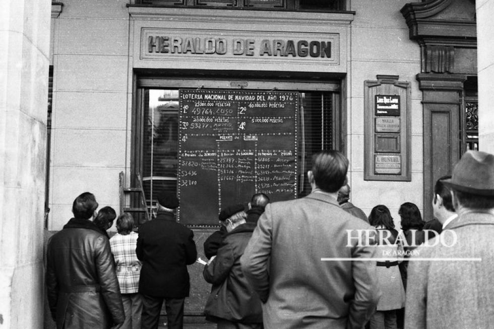 Esta imagen se repite cada año el 22 de diciembre, tras el sorteo del Gordo de Navidad, en la puerta de HERALDO DE ARAGÓN, en paseo de la Independencia 29 de Zaragoza. La fotografía corresponde al 22 de diciembre de 1976 donde un panel informa a los ciudadanos de los números premiados en el sorteo de la Lotería de Navidad.