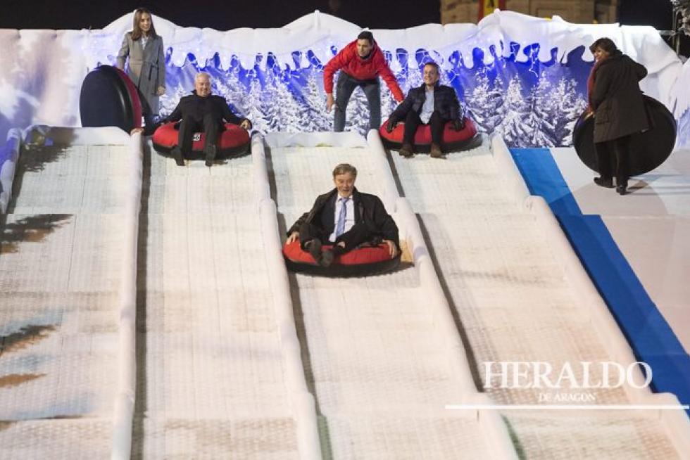 El alcalde de Zaragoza, Pedro Santisteve, prueba el trineo tobogán de la fuente de la Hispanidad de Zaragoza el 2 de diciembre, acompañado de María Navarro, Eloy Suárez, Fernando Rivarés y Reyes Campillo.