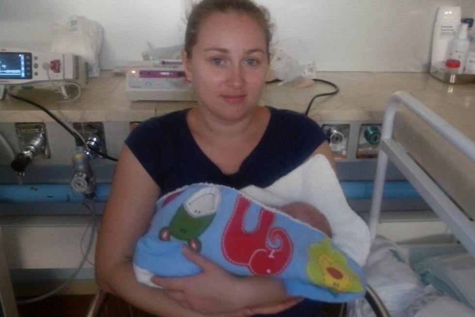 Una mamá de la asociación con su niño prematuro en un arrullo donado por Estelar.