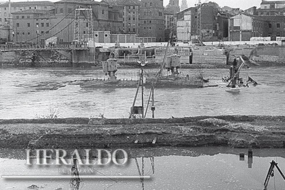 Esta fotografía de 1966 muestra cómo una de las riadas del Ebro de aquel año se llevó por delante el trabajo de todo un mes en la construcción del puente de Santiago. Fotografía incluida en el coleccionable 'Cómo hemos cambiado' que HERALDO DE ARAGÓN está regalando a sus lectores