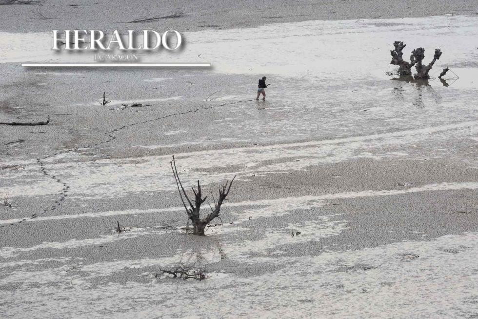 Ha sido un año crítico para Aragón en materia de sequía. En la imagen, una persona camina por la superficie del embalse de Yesa, que a principios de noviembre acumulaba 101 hectómetros cúbicos y no pasaba del 22,6% de su capacidad.