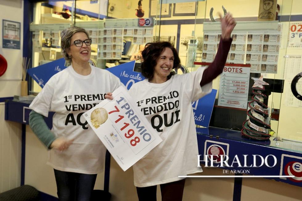 El Sorteo de Navidad reparte casi 27 millones de euros en Aragón. En la imagen, Carol López (derecha), esposa del dueño de la administración número 2 de Jaca, muestra el número del Gordo vendido allí.