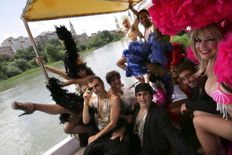 Miembros de la compañía La Cubana, que representan en Zaragoza la obra 'Comeme el coco, negro' en una de los ebrobús.