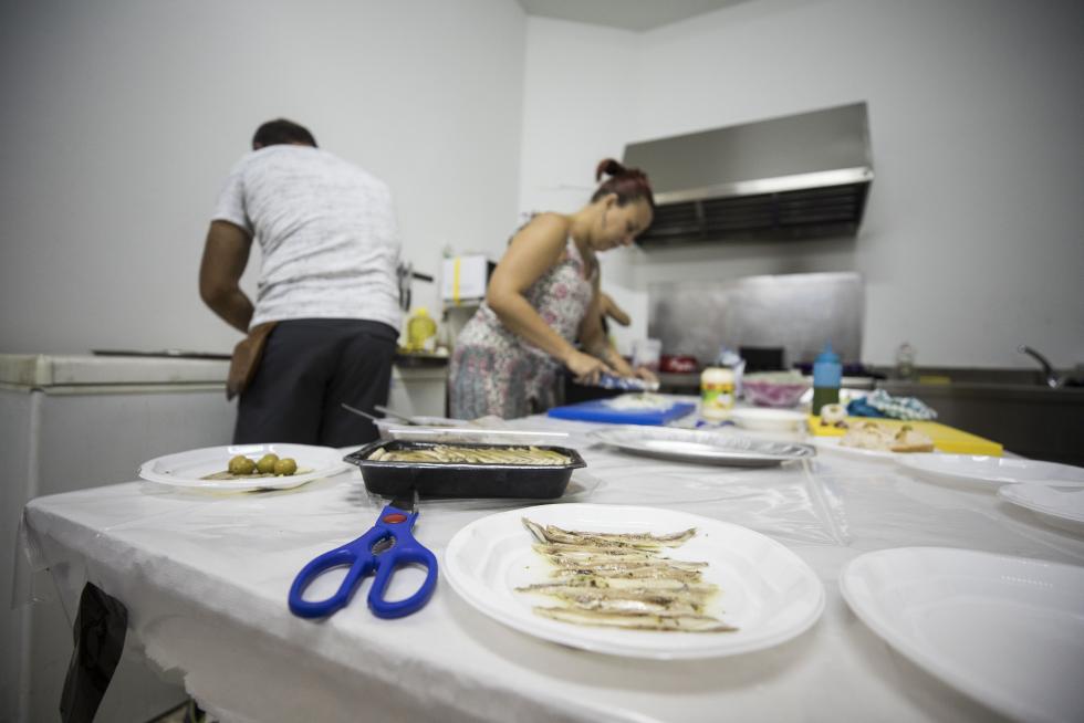 Conchita, Yolanda y Roberto, de la comisión de fiestas, preparando comida