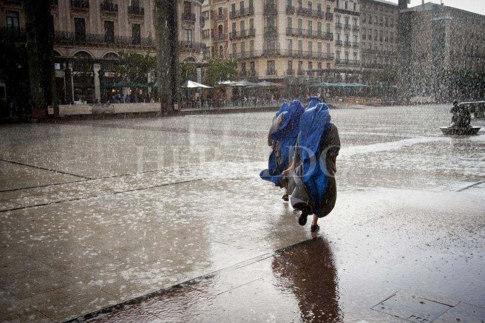 Dos monjas, atrapadas en una tormenta de verano en la plaza del Pilar en agosto de 2011