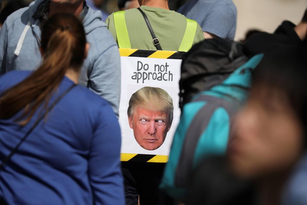 Varias personas esperan la llegada del presidente estadounidense Donald Trump en frente del Buckingham Palace de Londres.