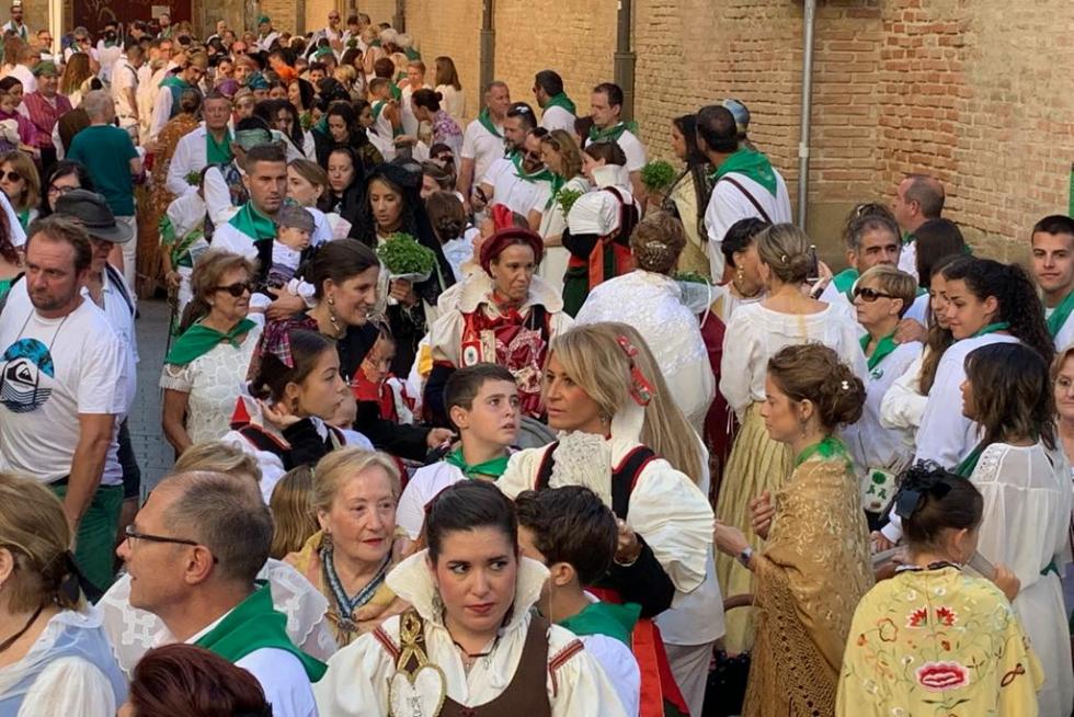 Los asistentes se incorporan desde las calles adyacentes a la plaza de San Lorenzo mientras los caballeros de la cofradía esperan la peana.