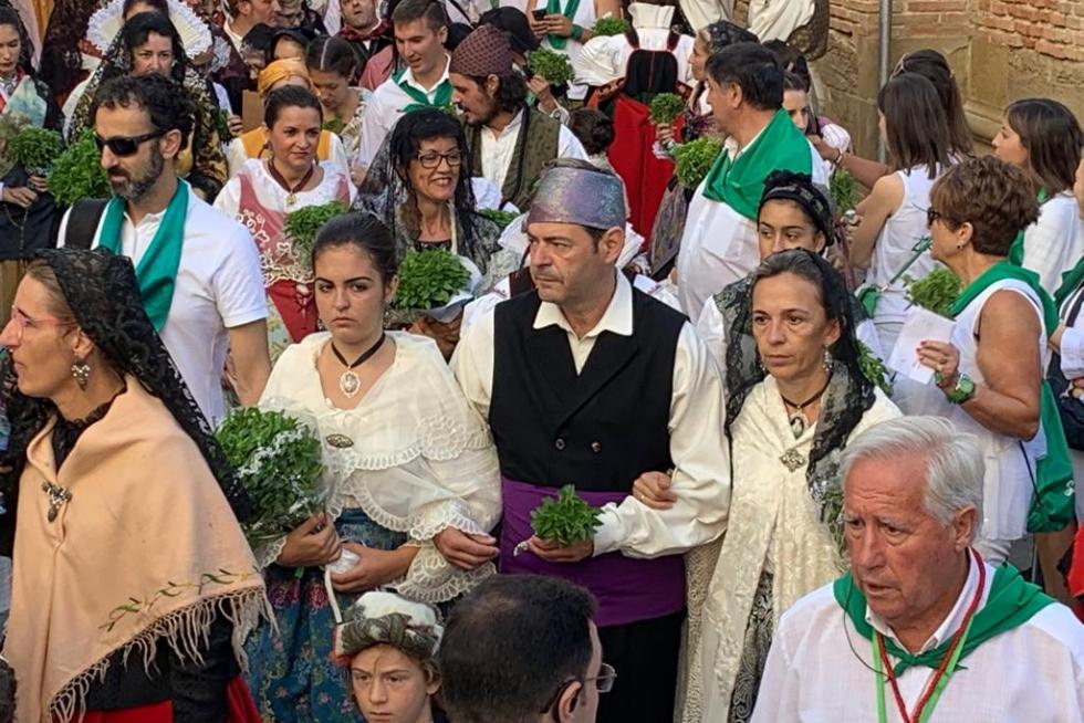 Los asistentes se incorporan desde las calles adyacentes a la plaza de San Lorenzo mientras los caballeros de la cofradía esperan la peana.