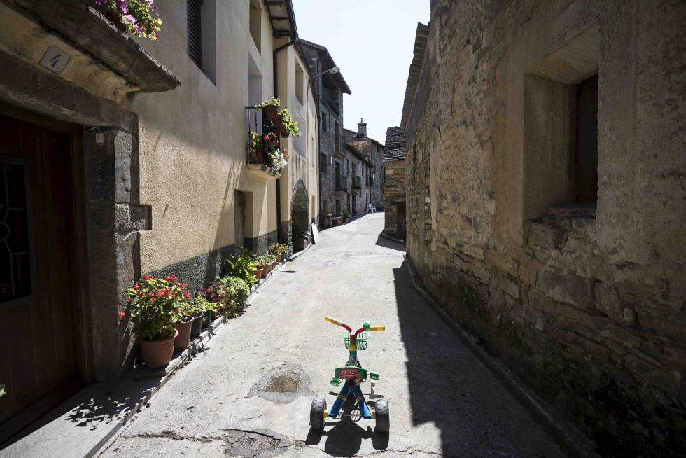 Triciclo y calle floreada en Tierrantona