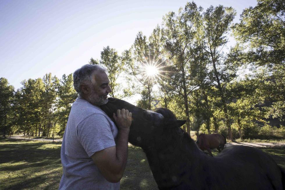 Andrés Pérez abraza a Farruco, parte de la docena de equinos integrados en la familia de Caballos Albarracín, en Moscardón