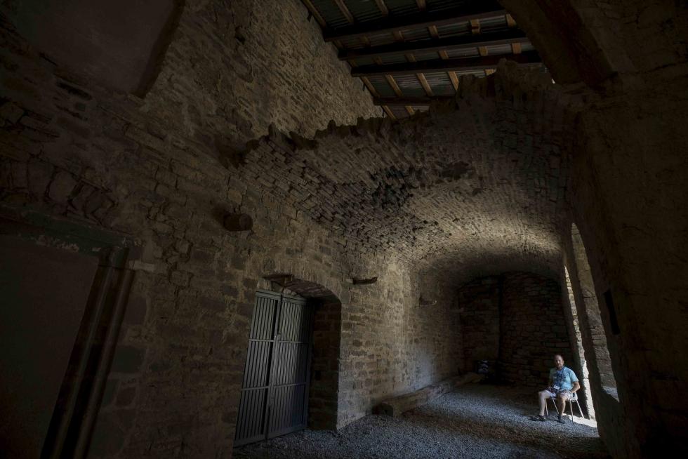El guía turístico y licenciado en Historia Miguel Antonio Cabeza, especializado en el Medievo, reposa tras la visita guiada en un ala del claustro de San Victorián, junto al acceso a la plaza del monasterio, en El Pueyo de Araguás
