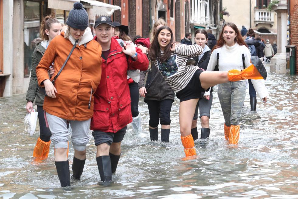 Venice (Italy), 17/11/2019.- A shop owner stands in the entrance to his briefly protected shop as tourists and residents resume their normal routine despite persistent flooding in Venice, Italy, 17 November 2019. High tidal waters returned to Venice on Saturday, four days after the city experienced its worst flooding in more than 50 years. (Italia, Niza, Venecia) EFE/EPA/EMILIANO CRESPI Aqua Alta in Venice