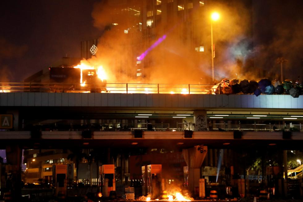 Hong Kong (China), 17/11/2019.- Pro-democracy protesters react after the police fired tear gas outside the Polytechnic University of Hong Kong in Hong Kong, China, 17 November 2019. Hong Kong is in its sixth month of mass protests, which were originally triggered by a now withdrawn extradition bill, and have since turned into a wider pro-democracy movement. (Protestas, Incendio) EFE/EPA/JEROME FAVRE Pro-democracy protesters and police clash.