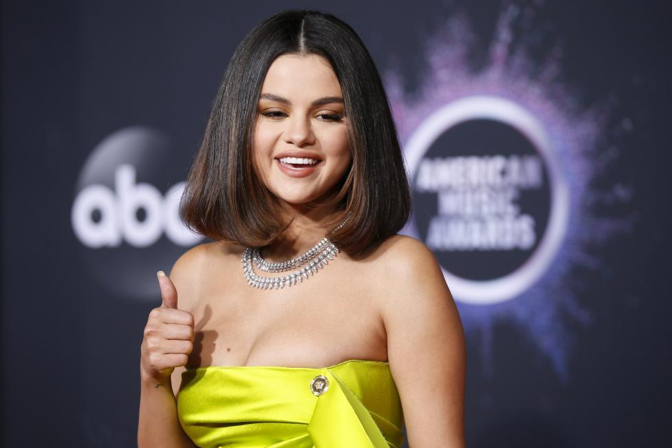 Selena Gomez en la alfombra roja de los American Music Awards con su llamativo vestido amarillo