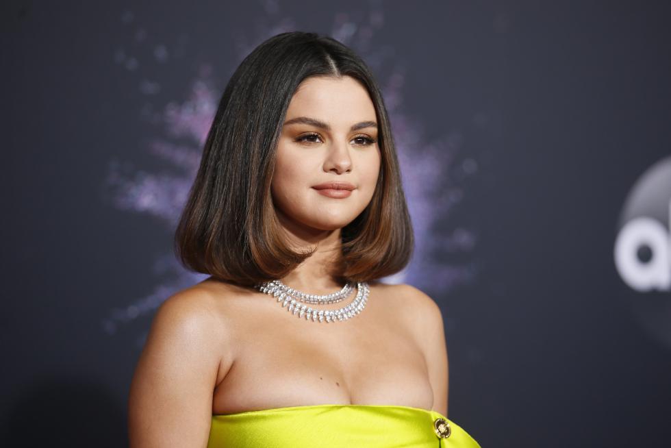 Selena Gomez en la alfombra roja de los American Music Awards con su llamativo vestido amarillo