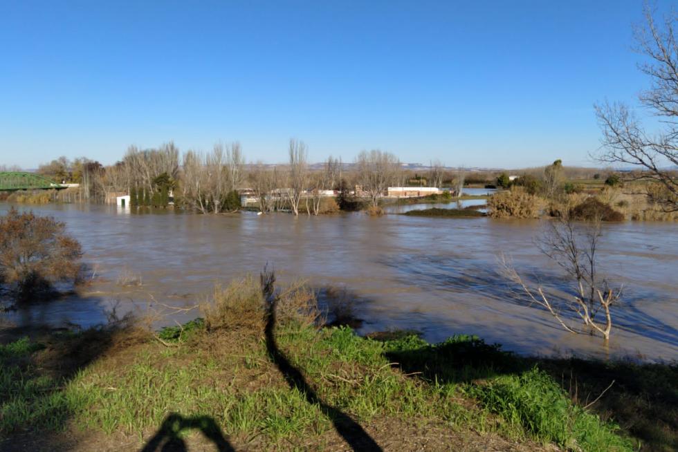 Vista del puente de Hierro de Gallur, con el Ebro desbordado. Al fondo, a la derecha, la carretera A-127, cortada por el agua.