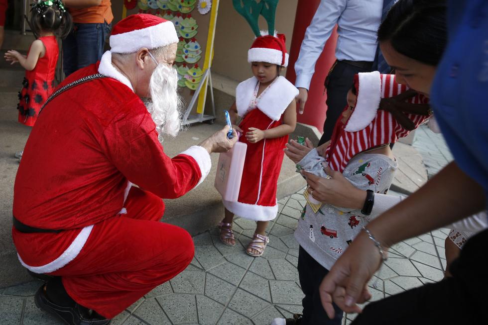 Bangkok (Thailand), 25/12/2019.- A foreign teacher (L) dressed as Santa Claus delivers gifts to his students during a Christmas Day mass at a school in Bangkok, Thailand, 25 December 2019. (Tailandia) EFE/EPA/NARONG SANGNAK Christmas Day in Bangkok