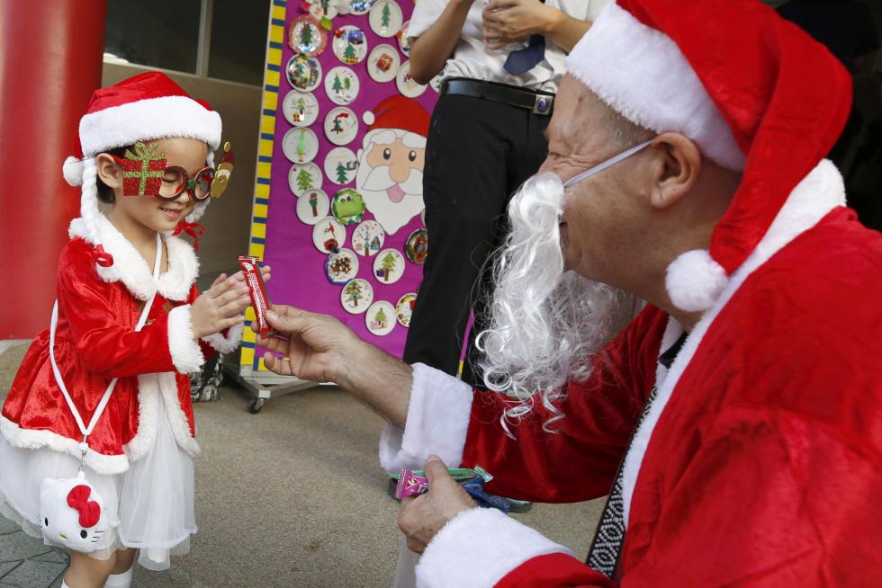 Bangkok (Thailand), 25/12/2019.- A foreign teacher (L) dressed as Santa Claus delivers gifts to his students during a Christmas Day mass at a school in Bangkok, Thailand, 25 December 2019. (Tailandia) EFE/EPA/NARONG SANGNAK Christmas Day in Bangkok