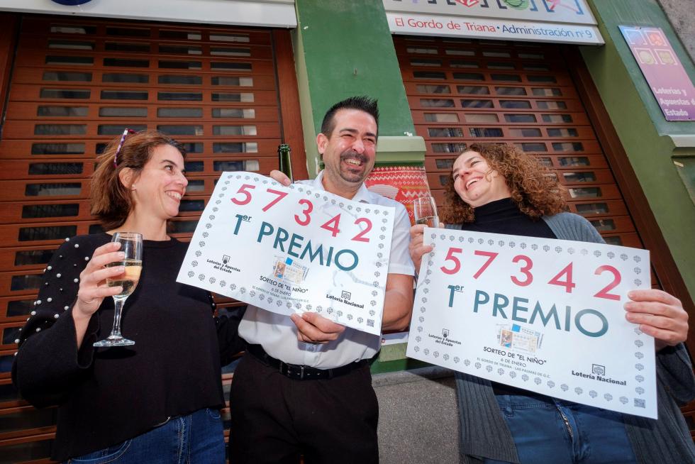 La administradora Ethel Mara Van Oudenhove Calero (d), su compañera en la administración Beatriz Memes Rodríguez (i) y un amigo de ambas, celebran haber repartido un décimo del primer premio