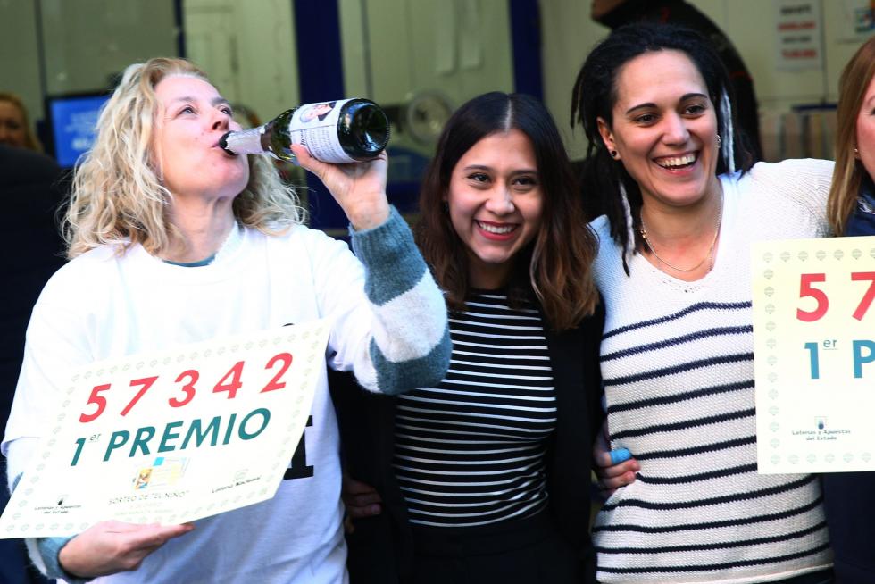 Un grupo de personas celebra en la administración de Lotería Doña Manolita haber dado parte del primer premio del sorteo del Niño