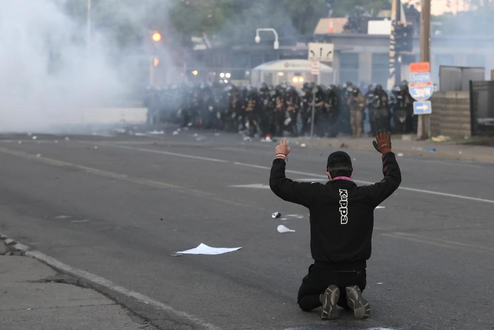 Washington (United States), 30/05/2020.- Police walk past a burning car during protests over the Minneapolis arrest of George Floyd, who later died in police custody, near the White House in Washington, DC, USA, 30 May 2020. A bystander's video posted online on 25 May, appeared to show George Floyd, 46, pleading with arresting officers that he couldn't breathe as an officer knelt on his neck. The unarmed black man later died in police custody. (Protestas, Estados Unidos) EFE/EPA/JIM LO SCALZO Police abuse protest in wake of George Floyd death, in Washington