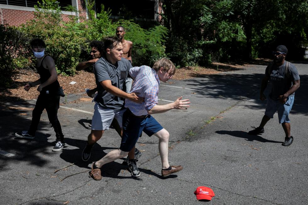 Boston (United States), 30/05/2020.- A protester wearing a Trump 2020 shirt, dances in front of a counter protester holding a sign that reads 'Covid 19 is Deadly Trump/Pence Regime is making it deadlier #outnow', in front of the Massachusetts Statehouse, in Boston, Massachusetts, USA, 30 May 2020. Massachusetts Governor has introduced a four phase plan to reopen the state in an effort to control the spread of the COVID-19 coronavirus disease. (Protestas, Abierto, Estados Unidos) EFE/EPA/CJ GUNTHER Protest for and against the reopneing the Commonwealth of Massachusetts