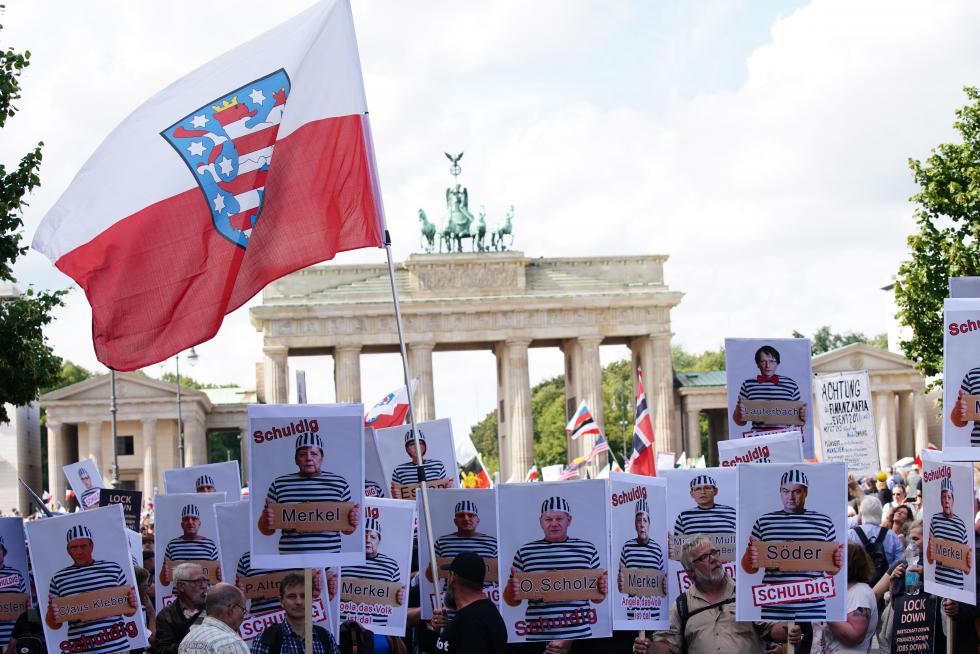 Berlin (Germany), 29/08/2020.- Demonstrators hold pictures of responsible persons in front of Brandenburg Gate, during a protest against coronavirus pandemic regulations in Berlin, Germany, 29 August 2020. The initiative 'Querdenken 711' and an alliance of right wing groups have called to demonstrate against coronavirus regulations like face mask wearing, in Berlin. Meanwhile forbidden, Berlin administrative court and higher administrative court allowed the demonstration to take place under certain requirements. Police announced to stop the demonstration when conditions were not met. (Protestas, Alemania) EFE/EPA/CLEMENS BILAN Demonstration against social and economic measures by Coronavirus pandemic