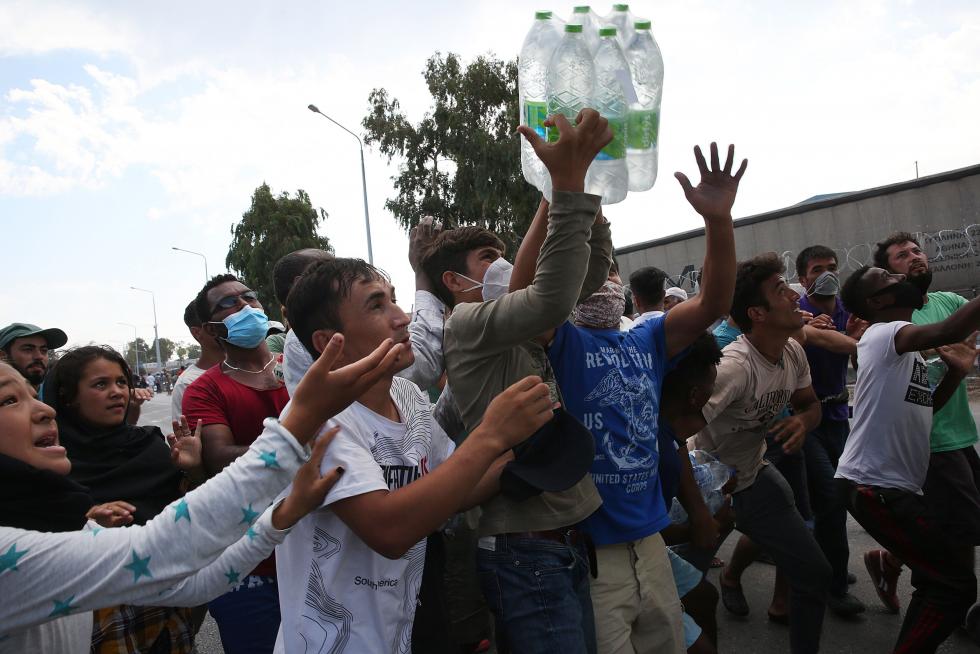 Kara Tepe (Greece), 12/09/2020.- Asylum seekers scuffle to get some water near the new camp at Kara Tepe on Lesbos island, Greece, 12 September 2020. Thousands of migrants and refugees are still without shelter following the successive fires at the Moria Reception and Identification Centre. A fire broke out in the overcrowded Moria Refugee Camp early 09 September 2020, destroying large parts of some 13,000 refugees' accommodations. The military camp which serves as a European Union's so-called 'hotspot' was designed to hold some 3,000 people, but has at times been the dwelling of some 20,000 refugees. (Incendio, Grecia, Estados Unidos) EFE/EPA/ORESTIS PANAGIOTOU Asylum seekers at the new camp at Kara Tepe