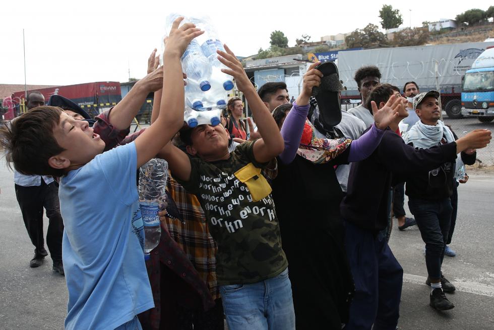 Kara Tepe (Greece), 12/09/2020.- Asylum seekers scuffle to get some water near the new camp at Kara Tepe on Lesbos island, Greece, 12 September 2020. Thousands of migrants and refugees are still without shelter following the successive fires at the Moria Reception and Identification Centre. A fire broke out in the overcrowded Moria Refugee Camp early 09 September 2020, destroying large parts of some 13,000 refugees' accommodations. The military camp which serves as a European Union's so-called 'hotspot' was designed to hold some 3,000 people, but has at times been the dwelling of some 20,000 refugees. (Incendio, Grecia, Estados Unidos) EFE/EPA/ORESTIS PANAGIOTOU Asylum seekers at the new camp at Kara Tepe