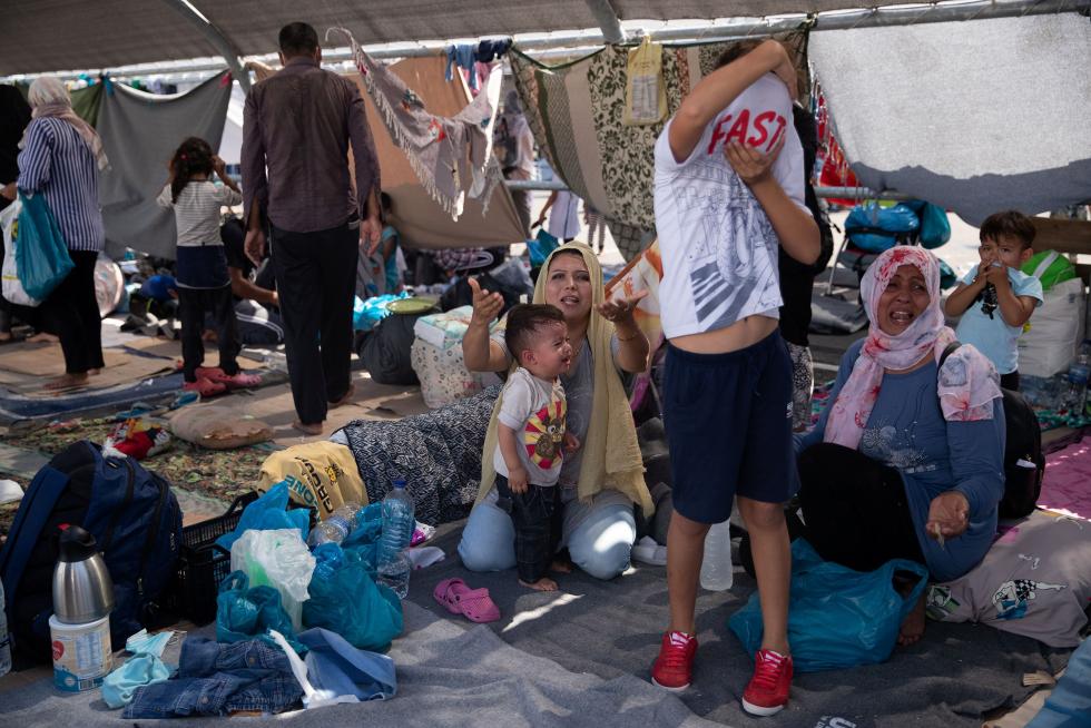Moria (Greece), 12/09/2020.- Asylum seekers try to take some water near the Moria refugees camp on the island of Lesvos, Greece, 12 September 2020. A passenger ferry and ?two Navy landing ships will accommodate about 2,000 of the homeless people after the fire at Moria, Migration and Asylum Minister Notis Mitarachi s?aid. The island of Lesvos was declared in state of emergency for four months, by order of Deputy Civil Protection and Management Crises Minister Nikos? Hardalias (Incendio, Grecia) EFE/EPA/ORESTIS PANAGIOTOU Asylum seekers enter the new refugees camp of Kara Tepe on Lesbos island