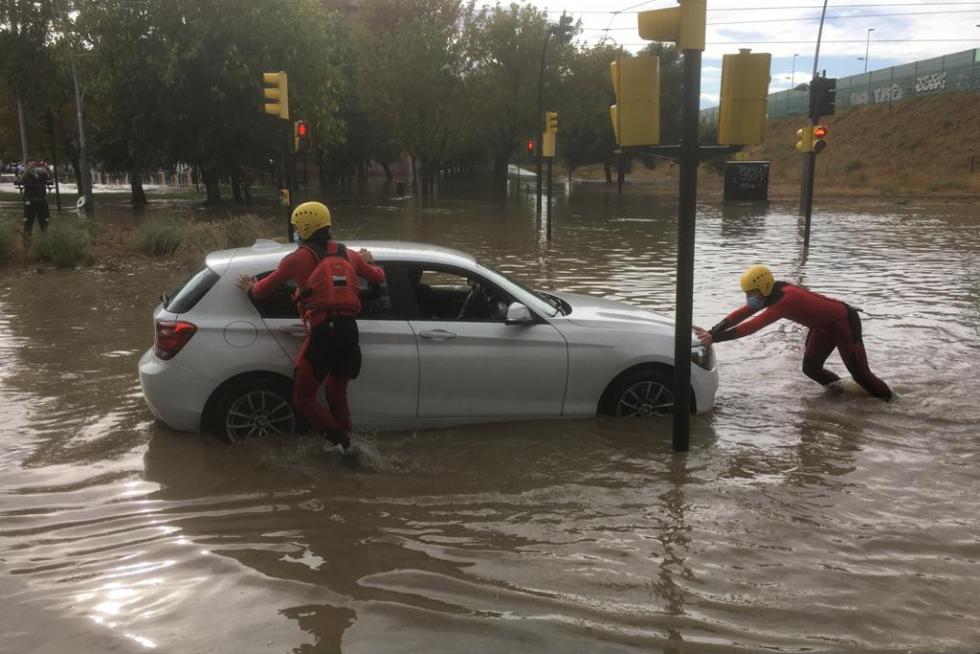 Intervención de los Bomberos de Zaragoza en la calle Luciano Gracia del Actur para ayudar a los coches afectados por la tromba de agua.