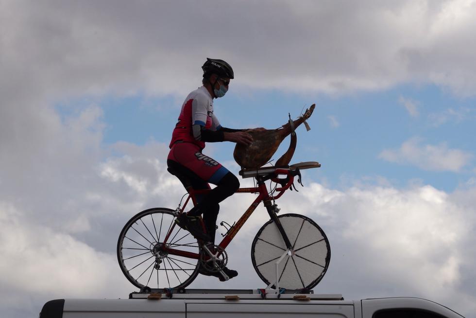 Un aficionado corta jamón en su bicicleta durante la cuarta etapa de la Vuelta Ciclista a España, entre Garray y Ejea de los Caballeros