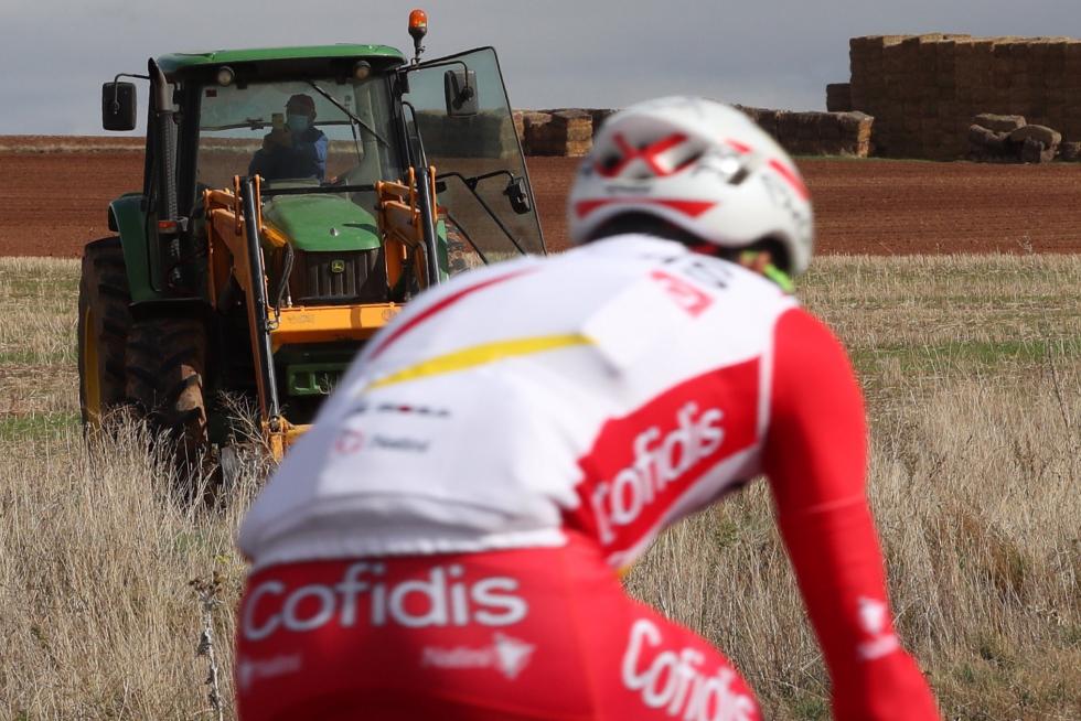 Un tractor observa el paso de uno de los ciclistas participantes en la cuarta etapa de la Vuelta que se disputa hoy entre Garray Numancia y Ejea de los Caballeros