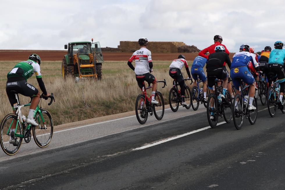 Un tractor observa el paso de uno de los ciclistas participantes en la cuarta etapa de la Vuelta que se disputa hoy entre Garray Numancia y Ejea de los Caballeros