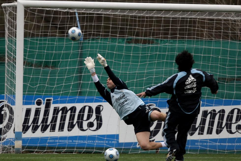 En su etapa como entrenador de la selección argentina de fútbol, le remata un balón a su guardameta, Juan Pablo Carrizo, durante un entrenamiento en Buenos Aires. 01/09/09