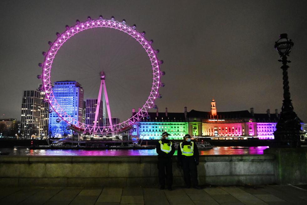 Dos policías delante del London Eye iluminado en una Londres semivacía