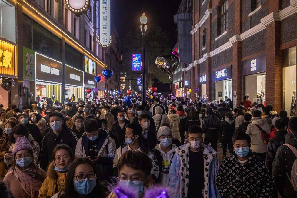 Wuhan (China), 31/12/2020.- People walk in a street on New Year's Eve in Wuhan, China, 31 December 2020. Life in Wuhan, a Chinese city of more than 11 million, which nearly a year ago became the epicenter of the coronavirus outbreak is returning to normal. EFE/EPA/ROMAN PILIPEY New Year in Wuhan
