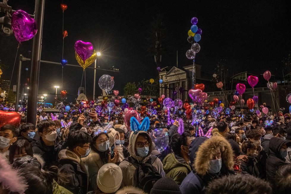 Wuhan (China), 31/12/2020.- Women take selfies as they gather in a street to celebrate the New Year in Wuhan, China, 31 December 2020. Life in Wuhan, a Chinese city of more than 11 million, which nearly a year ago became the epicenter of the coronavirus outbreak is returning to normal. EFE/EPA/ROMAN PILIPEY New Year in Wuhan