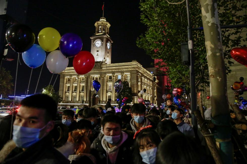 Wuhan (China), 31/12/2020.- People gather in a street to celebrate the New Year in Wuhan, China, 31 December 2020. Life in Wuhan, a Chinese city of more than 11 million, which nearly a year ago became the epicenter of the coronavirus outbreak is returning to normal. EFE/EPA/ROMAN PILIPEY New Year in Wuhan
