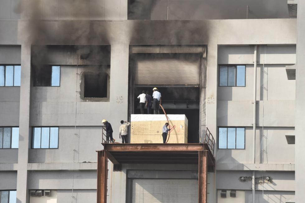Pune (India), 21/01/2021.- Indian workers stand outside a building of the Covid vaccine-maker Serum Institute of India's Pune facility after a fire broke out in Pune Maharashtra, India, 21 January 2021. A massive fire broke out in one of an under construction building of the facility which is spread over 100 acres and no damage and causality reported as many fire engines reached the spot. (Cine, Incendio, Estados Unidos) EFE/EPA/STR Fire at the Serum Institute of India's Pune facility in India