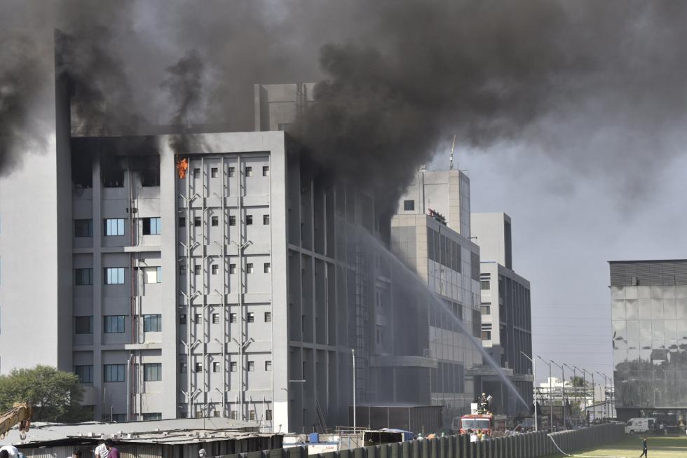 Pune (India), 21/01/2021.- Indian workers stand outside after a fire broke out at a building of the Covid vaccine-maker Serum Institute of India's Pune facility in Pune Maharashtra, India, 21 January 2021. A massive fire broke out in one of an under construction building of the facility which is spread over 100 acres and no damage and causality reported as many fire engines reached the spot. (Cine, Incendio, Estados Unidos) EFE/EPA/STR Fire at the Serum Institute of India's Pune facility in India