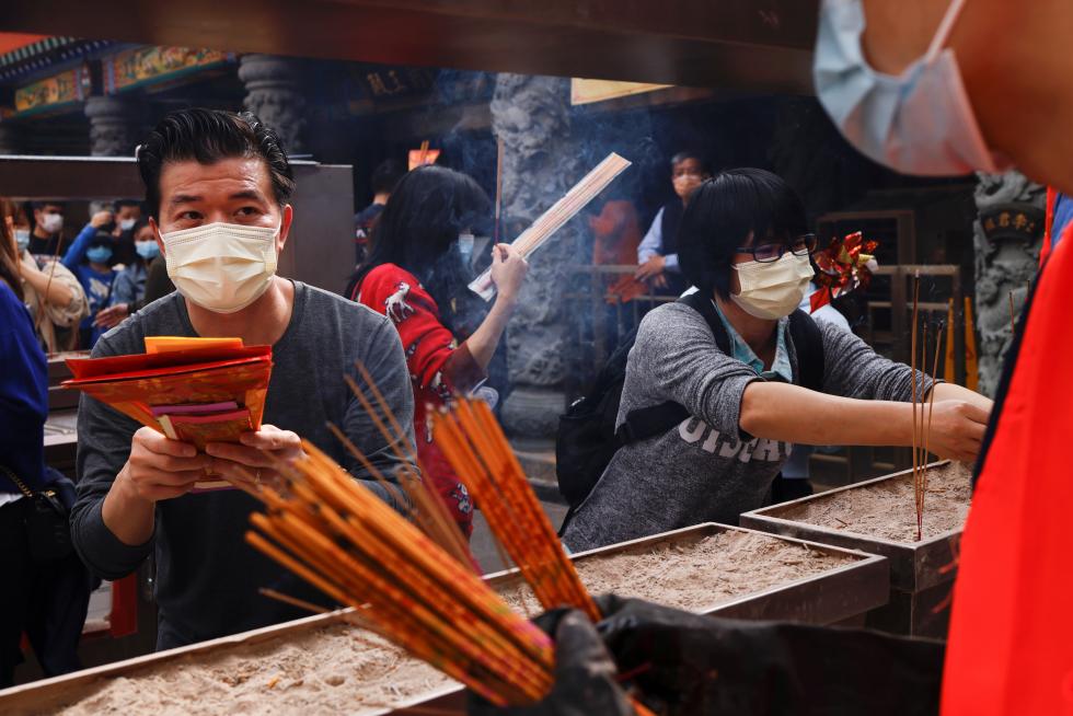 Worshippers wearing face masks make offerings of incense sticks during the first day of Chinese Lunar New Year, following the coronavirus disease (COVID-19) outbreak, at Wong Tai Sin Temple, in Hong Kong