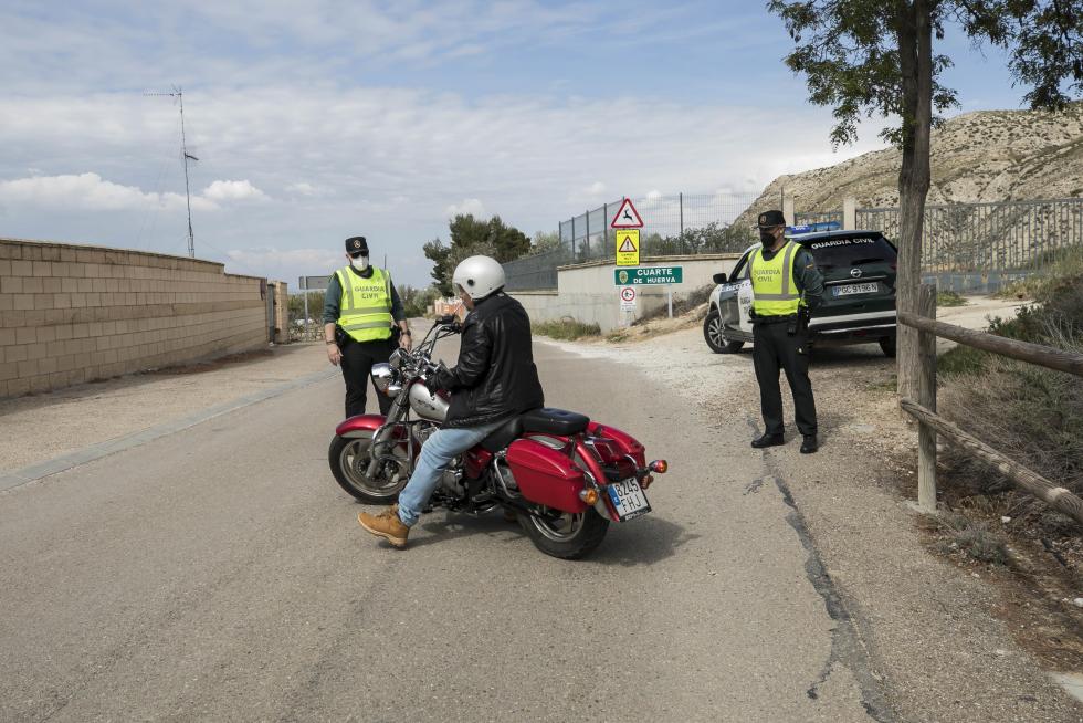 Controles de la Guardia Civil a coches, motos y bicicletas en los accesos a Cuarte de Huerva por su confinamiento perimetral.