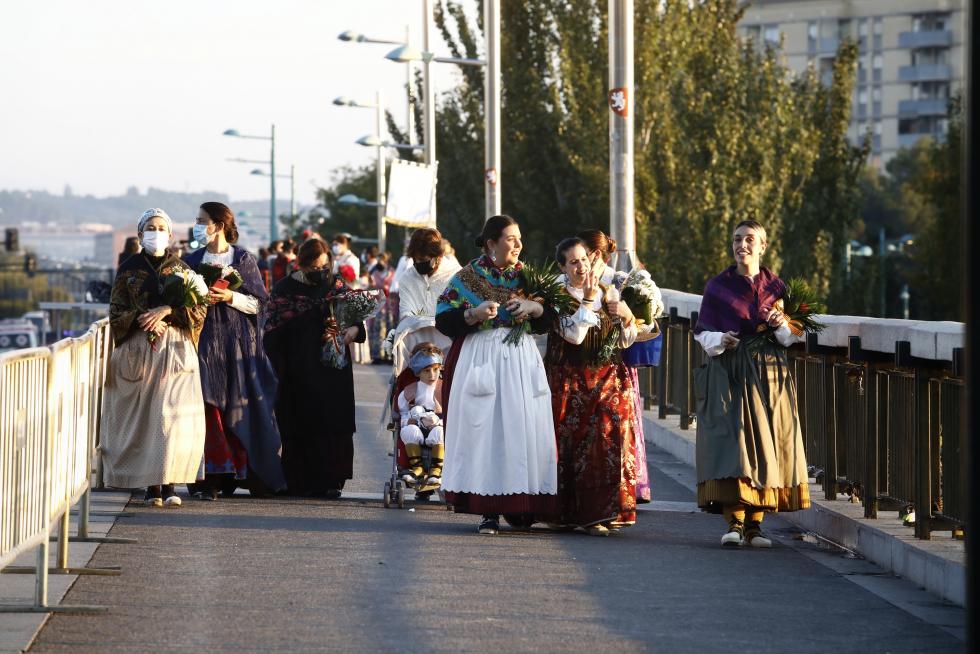 La Ofrenda va avanzando, el manto de la Virgen se está cubriendo ya y el color inunda la plaza. Al otro lado de las vallas, algunos curiosos intentan vislumbrar lo que ocurre.